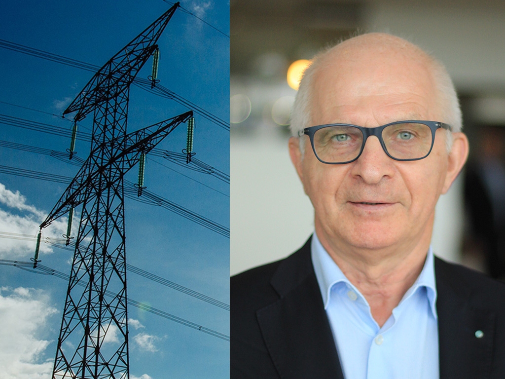 Portrait of a senior man wearing a light blue shirt and a blazer, set against a background of blue sky and power lines.