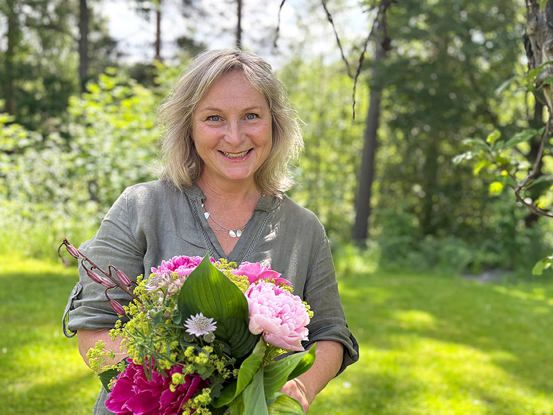 Person med blommor i famnen