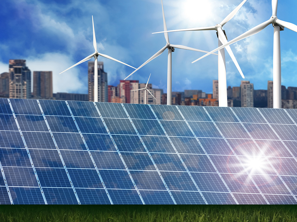 Solceller, vindkraftverk och byggnader i bakgrunden