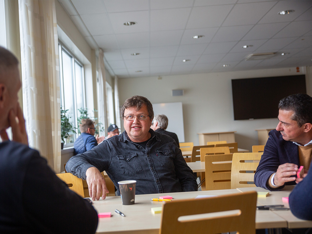 Några män sitter runt ett bord och diskuterar smart styrning av energi.